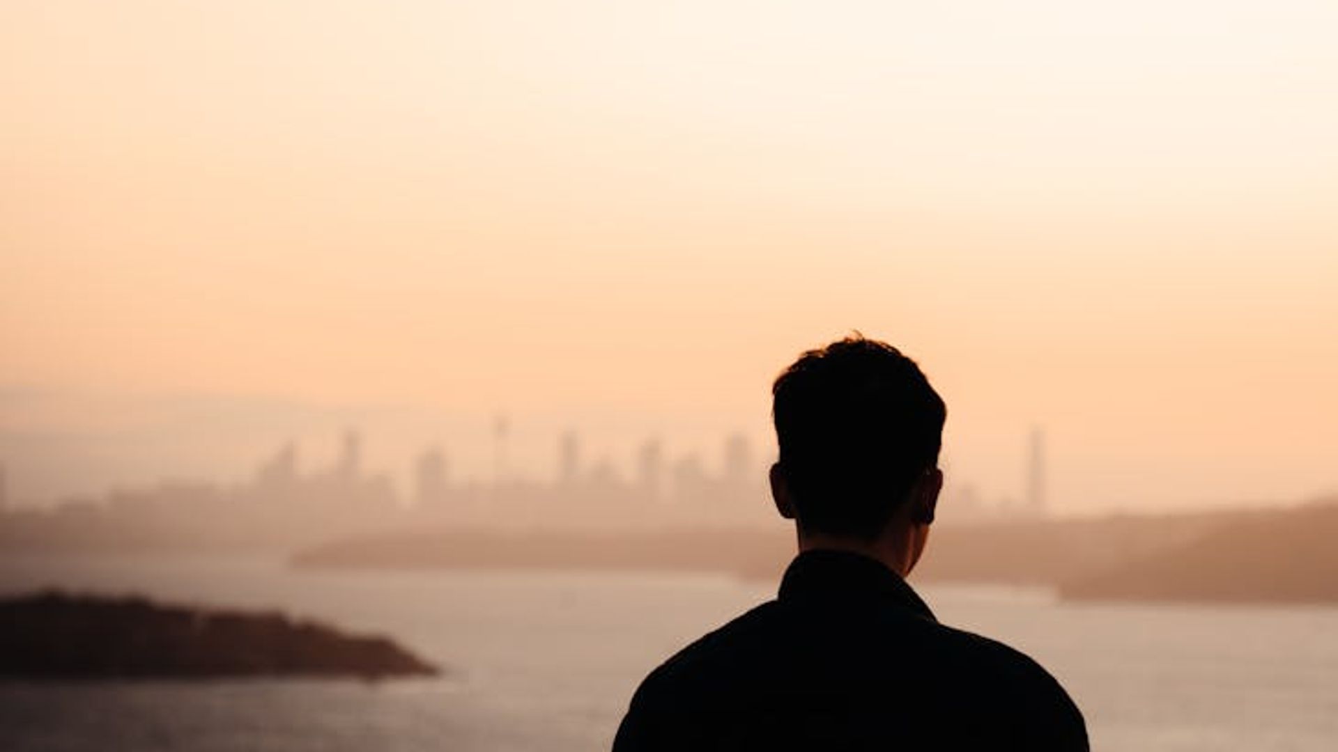 Person looking calmly into the distance near a bright window